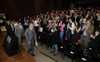 Tomaz Aroldo foi recebido de pé pela plateia e conduzido à mesa por um grupo de professores e técnicos-administrativos (Foto: Foca Lisboa / UFMG)